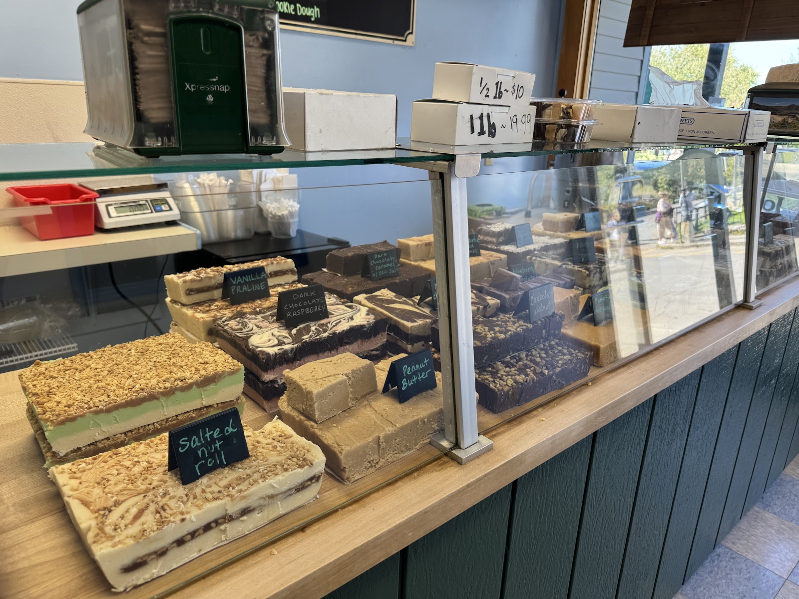 Thick fresh-cut slices of fudge in the case, labeled vanilla praline, dark chocolate raspberry, peanut butter and more.