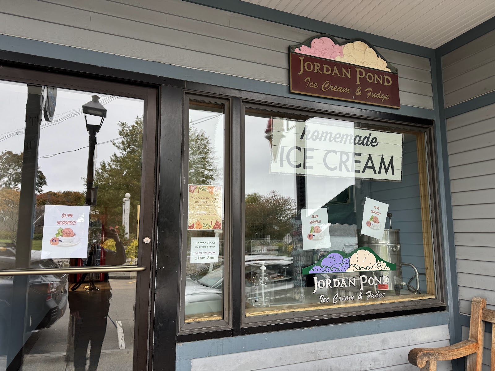 The storefront window with the carved sign, the painted mountains-and-scoops logo, and homemade ice cream signs.